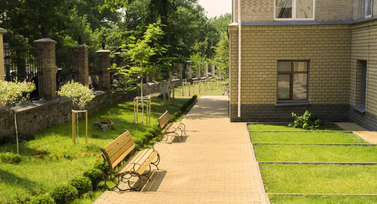 Entretien des espaces verts : allée d'hôpital aménagée avec bancs, pelouses et arbres