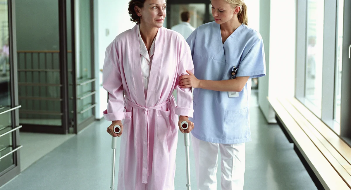 infirmière et patiente dans une chambre d'hôpital avec vue sur jardin
